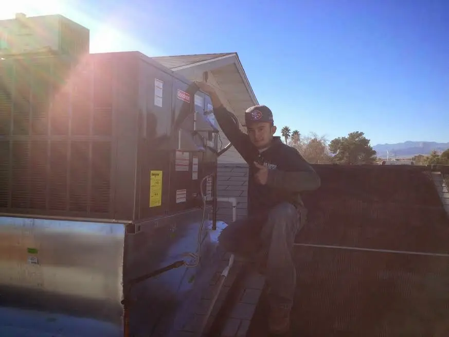 HVAC technician performing Heat Pump Repair on a rooftop unit in Sullivan